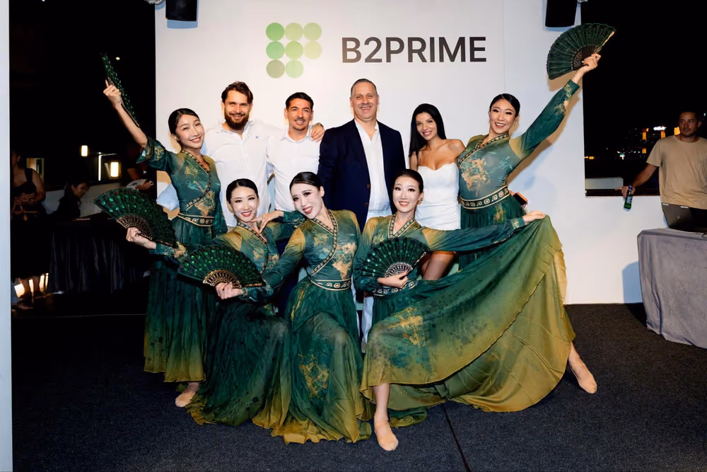 Танцовщицы в зеленом выступают с веерами на B2MEET Hong Kong на фоне B2PRIME