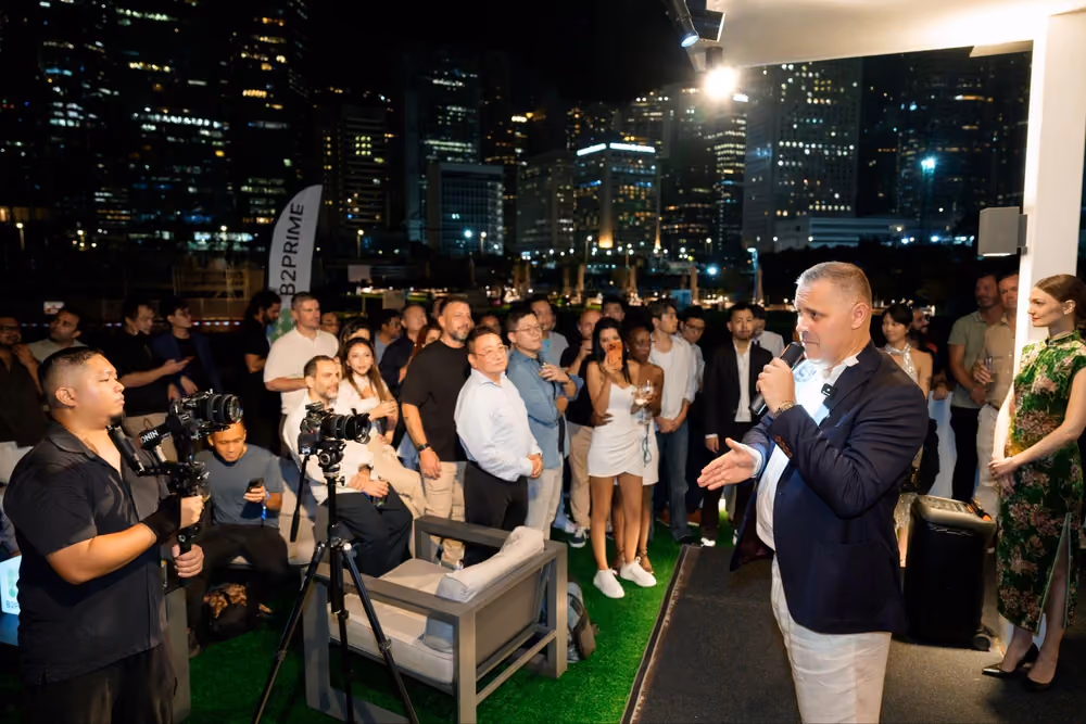 Спикер обращается к гостям B2MEET Hong Kong, за яхтой — панорама Гонконга